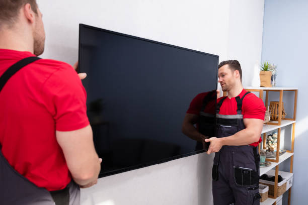 Movers Fixing The Large Flat LCD Television On Wall In The Living Room