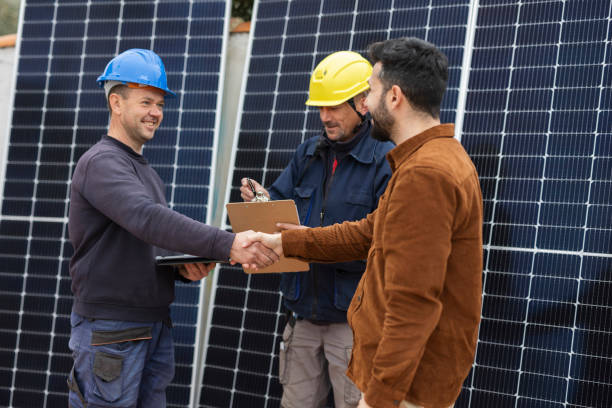 Businessman and engineers shake hands. Owner acquires solar panels and closes agreement